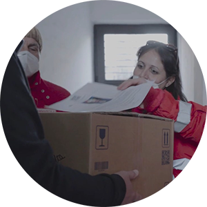 Carlotta Gilli consegna dei pacchi di prodotti con la Croce Rossa Italiana