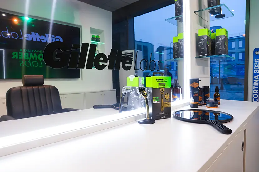 La foto è scattata a uno specchio, dove si vede riflessa l’area che ospita la barber station di Gillette, con il prodotto Gillette Labs Gold in primo piano.