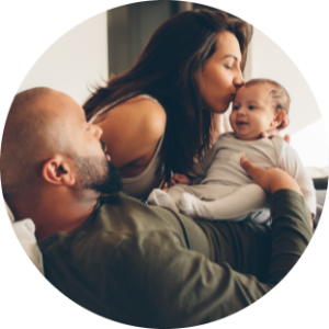 Una mamma e un papà abbracciando sul letto la loro figlia