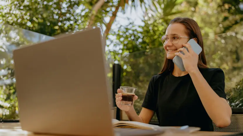 Una ragazza lavora al proprio computer da un cortile