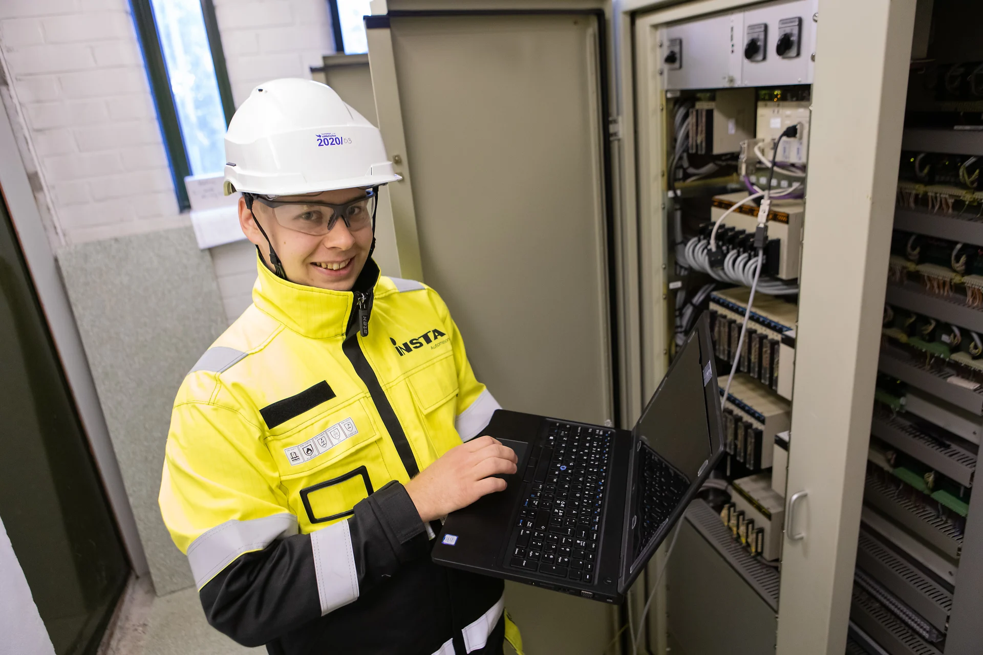 Instan työntekijä lämpölaitoksessa kannettavan tietokoneen kanssa.