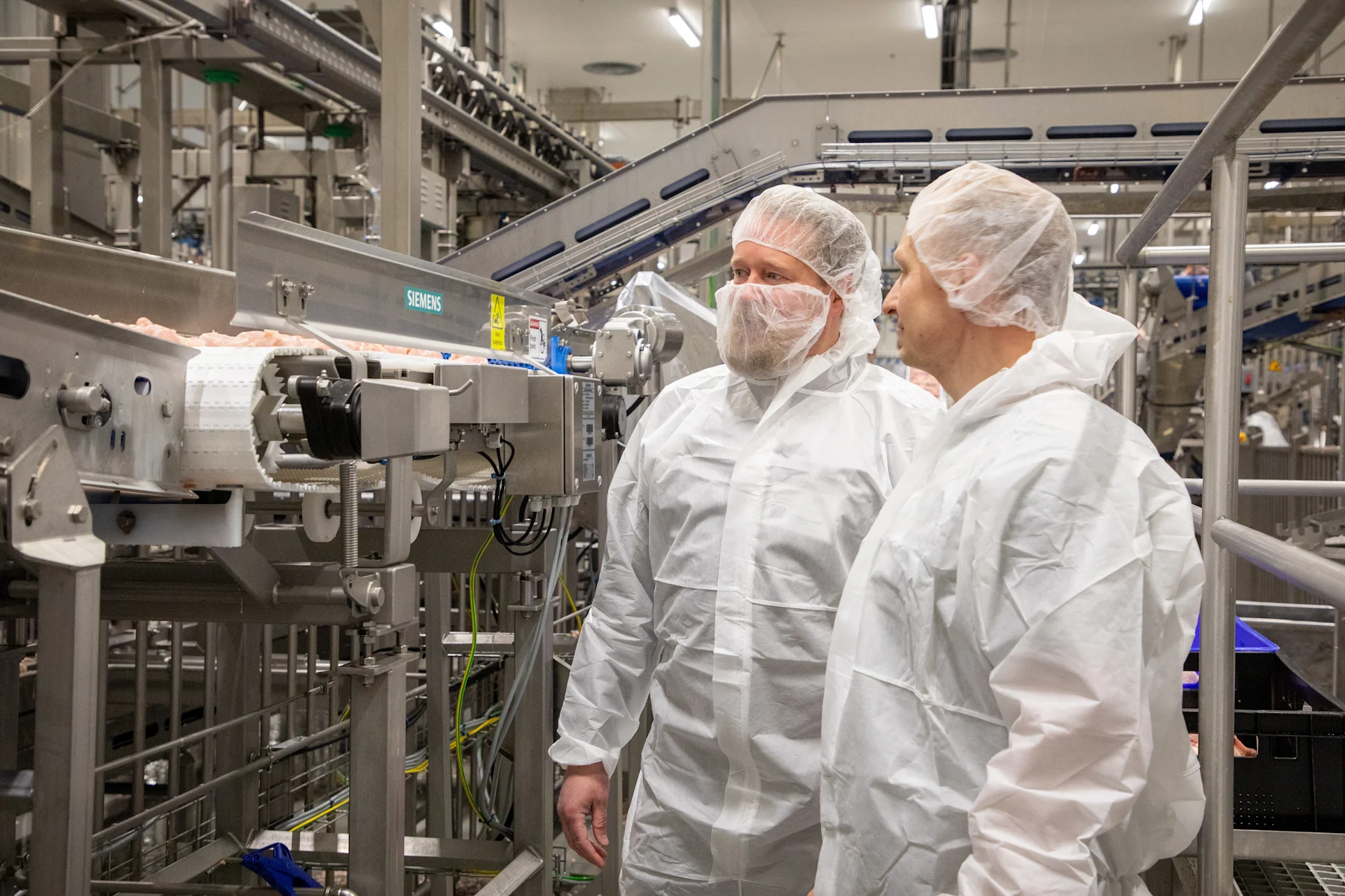 Insta's Rainer Granrot and Atria's Tommi Kumpulainen at Atria Plc’s poultry production plant. On the left is a Siemens’ scale.