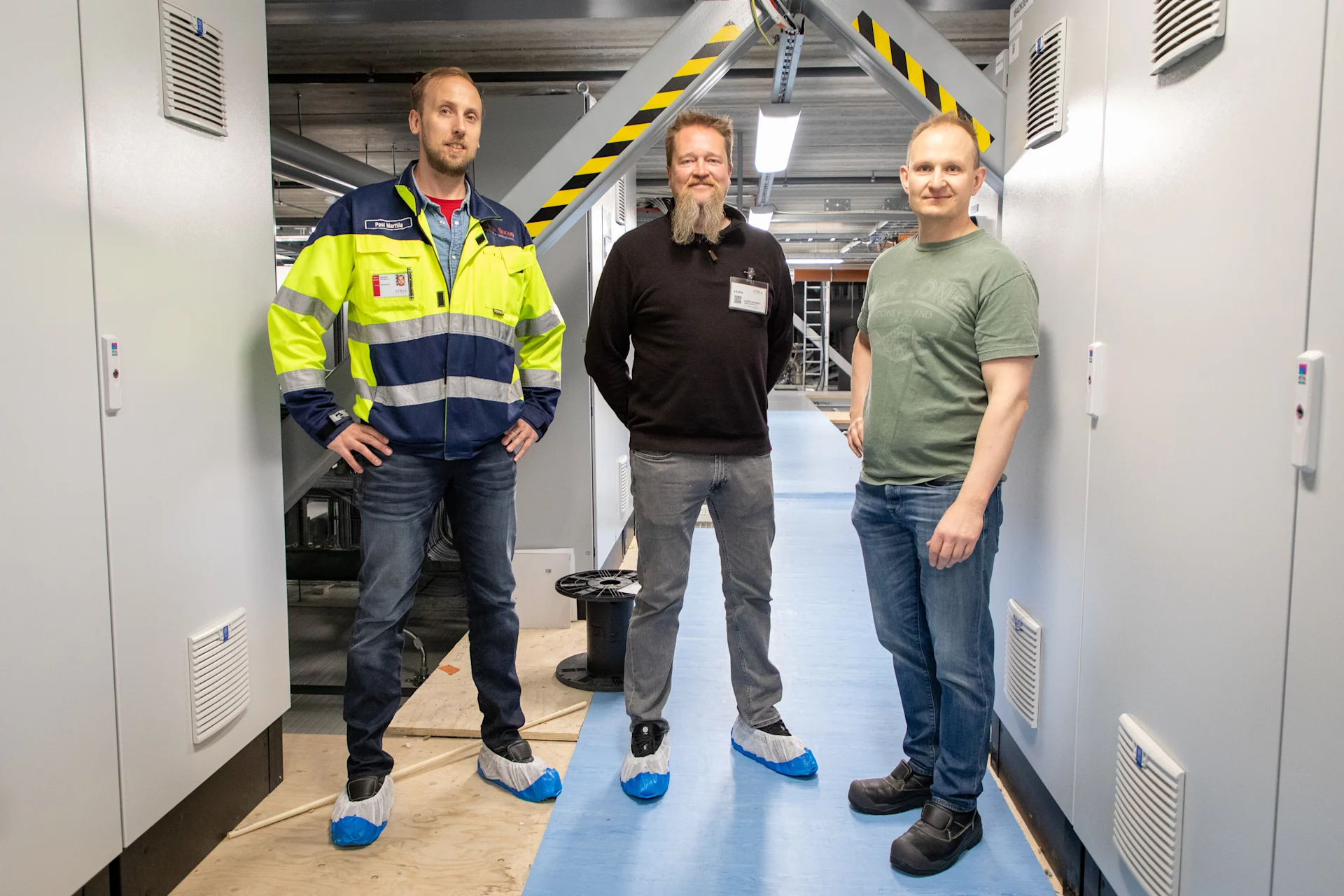 In the electrical room of Atria's Nurmo poultry plant, Atria's Pasi Marttila, Insta's Rainer Granrot, and Atria's Tommi Kumpulainen.