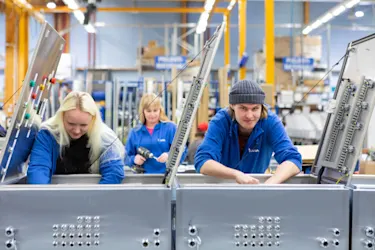 Instan asentajat kumartuneina automaatiokeskusten ääreen.