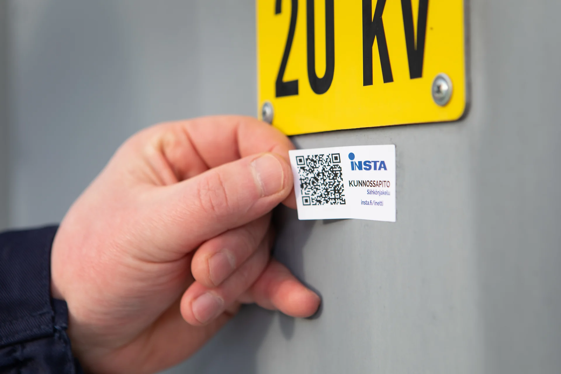 The iNetti sticker is glued to the door of the transformer. The picture shows a close-up of a hand.