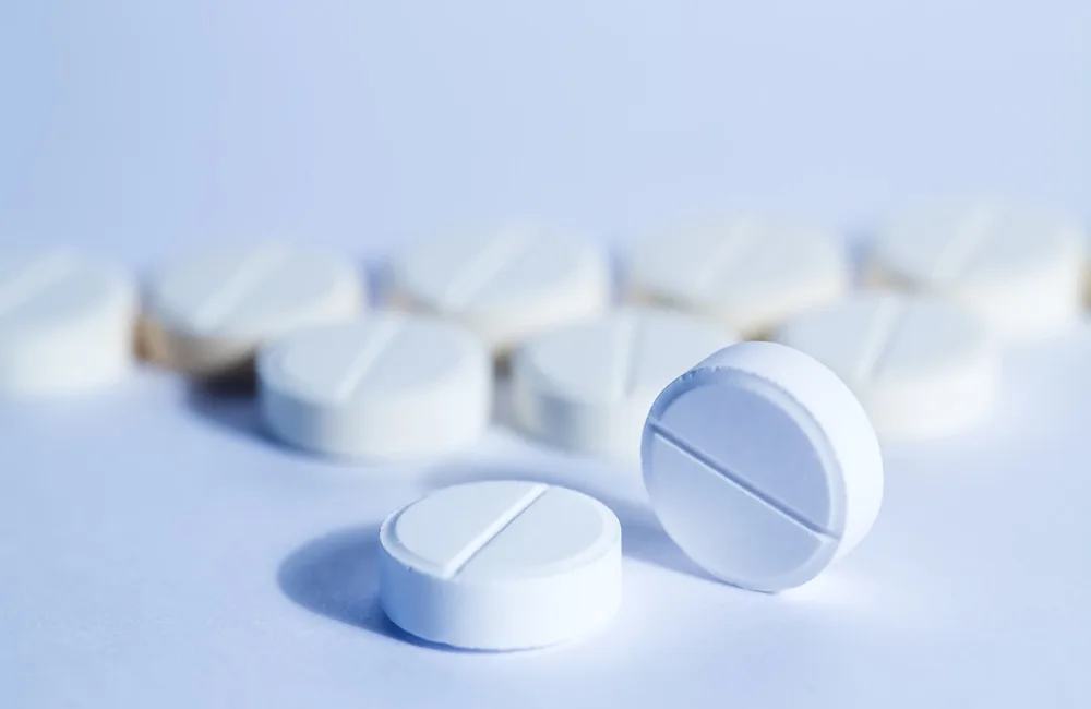 Round pharmaceutical tablets on a white surface