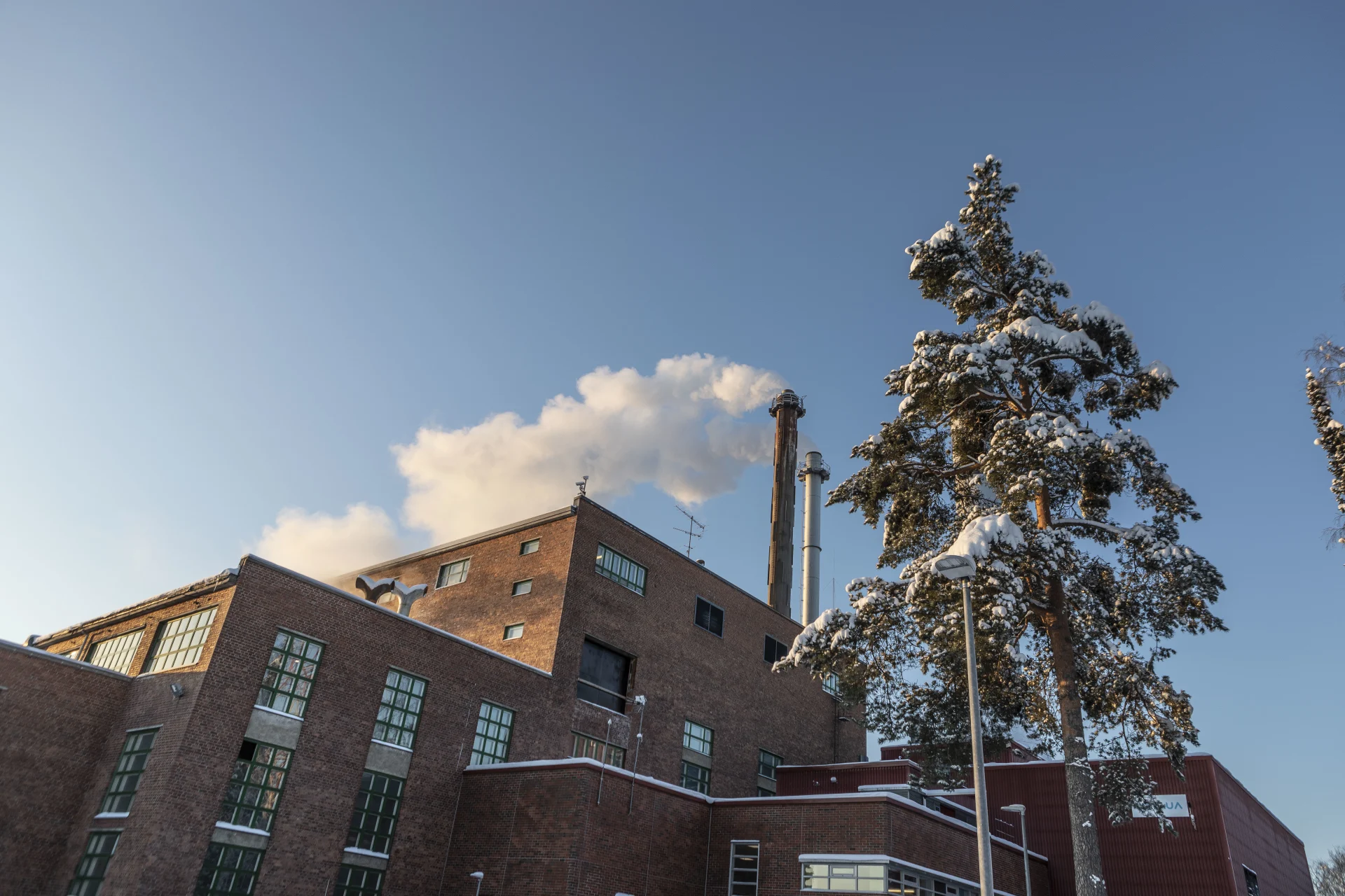 Loimua district heating plant in winter, blue sky in the background.