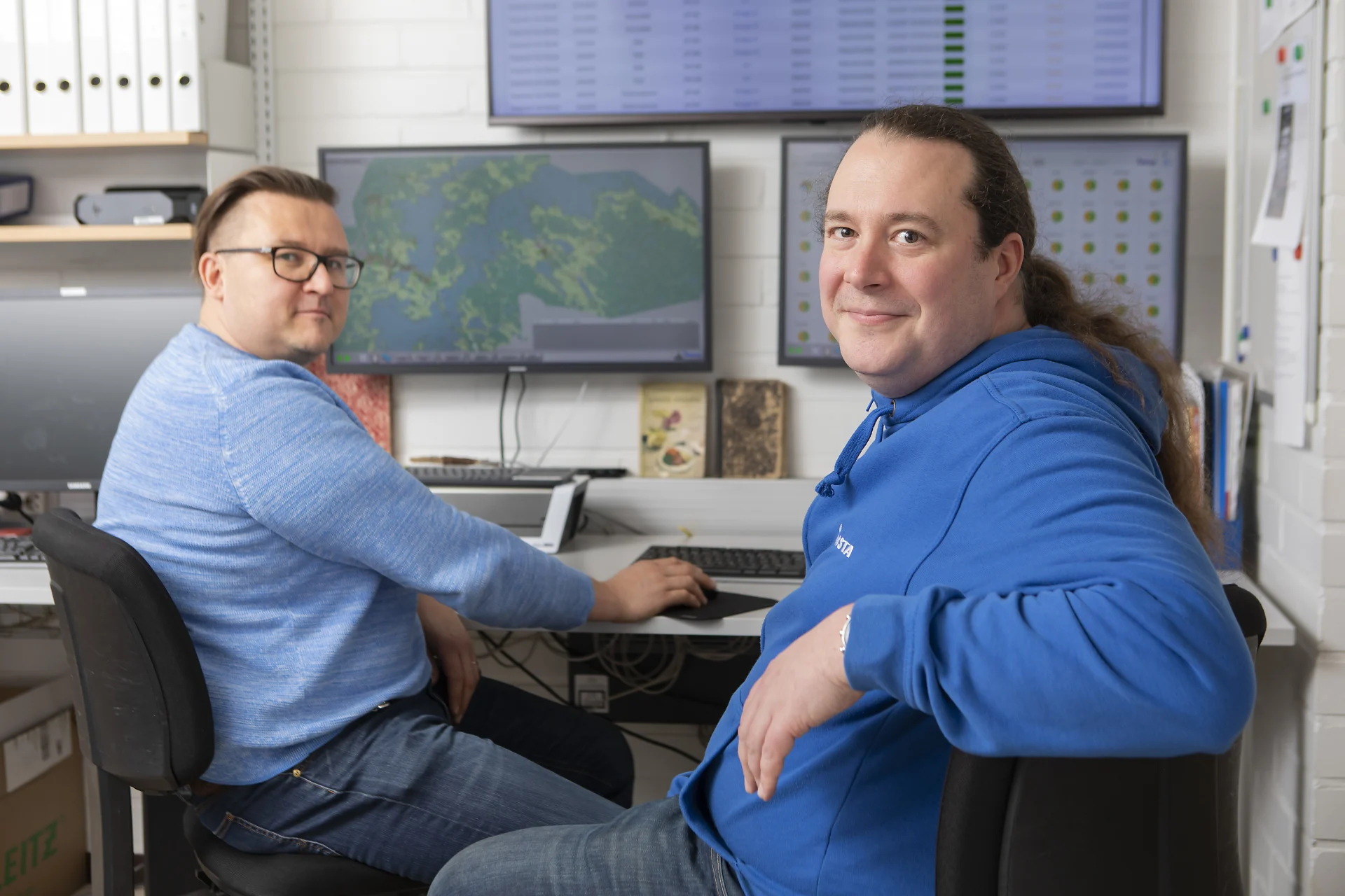 Kangasalan Vesi corporation's Mauno Annala and Insta's Arttu Hanhela sitting by the screens. A map view and situational picture graphs are displayed.