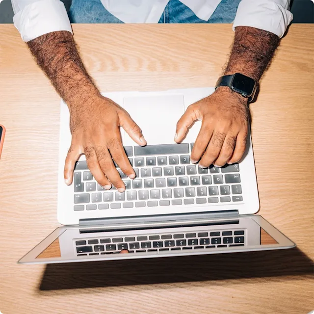 Hands pounding on laptop keyboard.