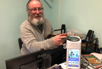 Photo of Geoff who runs the PACE food bank with a CollecTin More contactless donation box that uses a Stripe card reader and Give A Little software