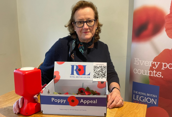 Alison Opfermann pictured with a poppy collection box and QR code for the Jersey Poppy Appeal