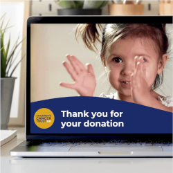 Laptop showing fundraising campaign thank you screen with girl clapping.