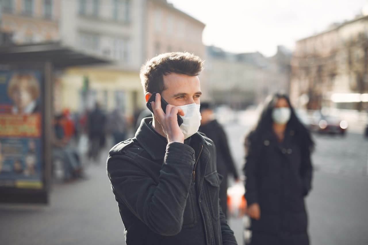 Mężczyzna w amseczce rozmawia przez telefon komórkowy na ulicy.