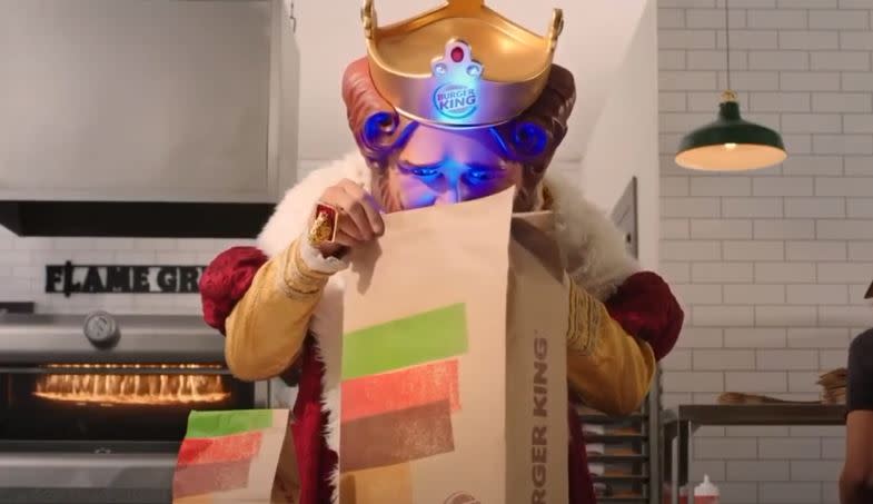 Kadr ze zwiastuna Burger Kinga. Król Burgerów otwiera torbę, z których wydobywa się niebieska poświata.