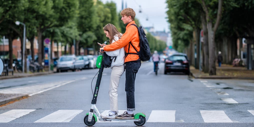 Para jadąca na hulajnodze elektrycznej przez przejście dla pieszych