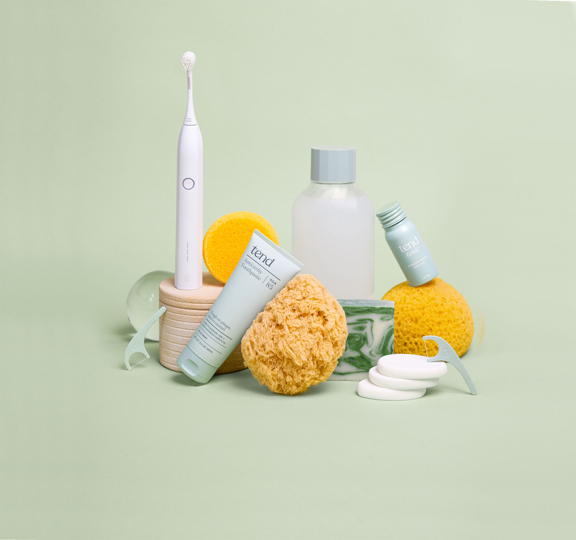 A Soothsonic, Anticavity Toothpaste, Tonic, and floss harps displayed with sponges and soaps