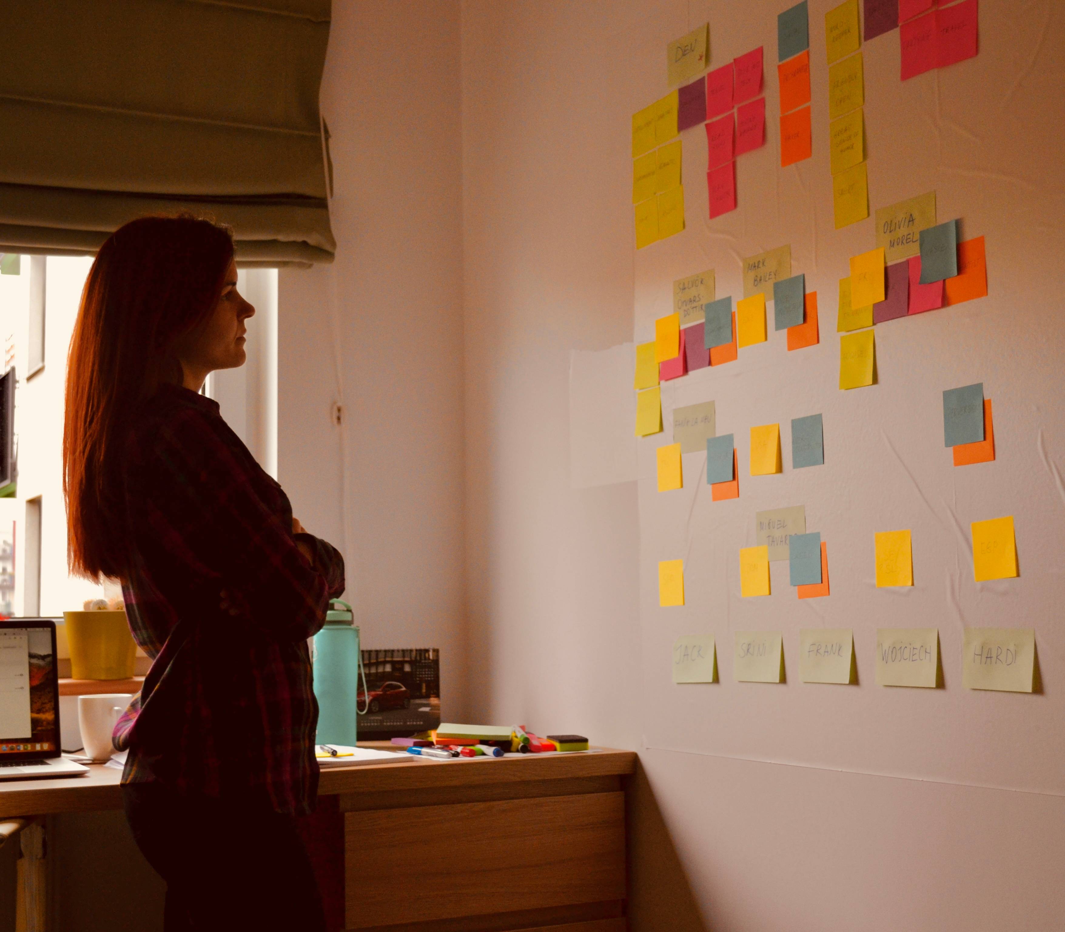 Author is looking at the whiteboard filled with colorful sticky notes.