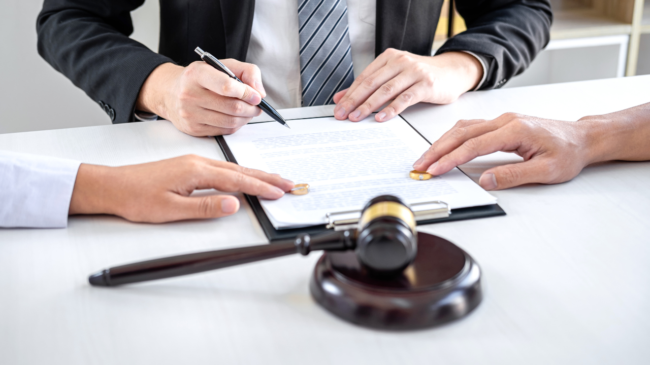 A couple signing divorce papers with a lawyer.