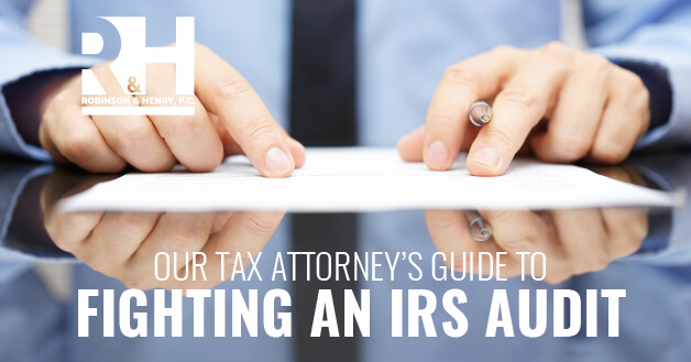 A man looks over a contract to hire a tax attorney to fight his IRS audit