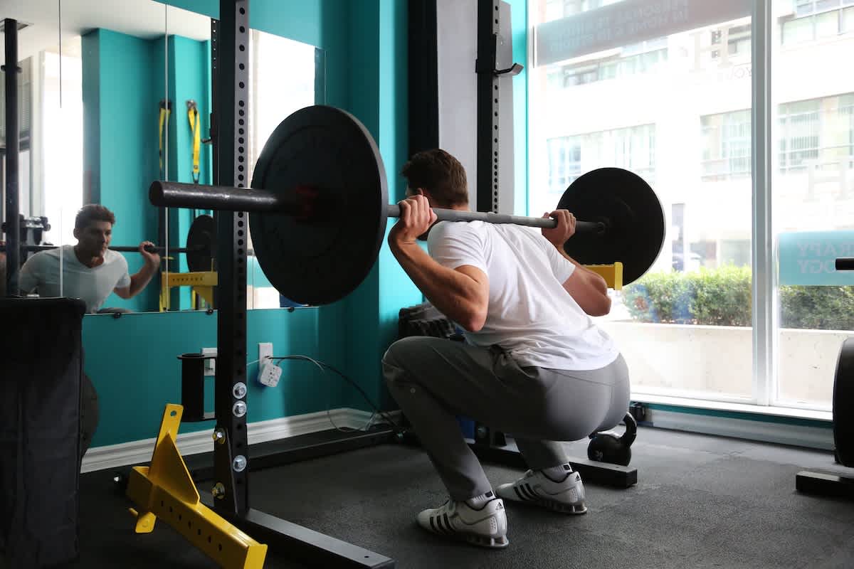 Man at gym doing a squat