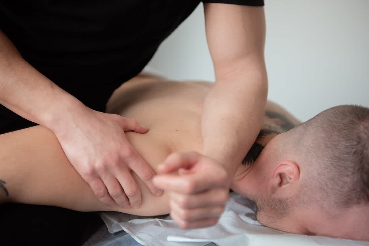 Deep tissue massage on man's upper back