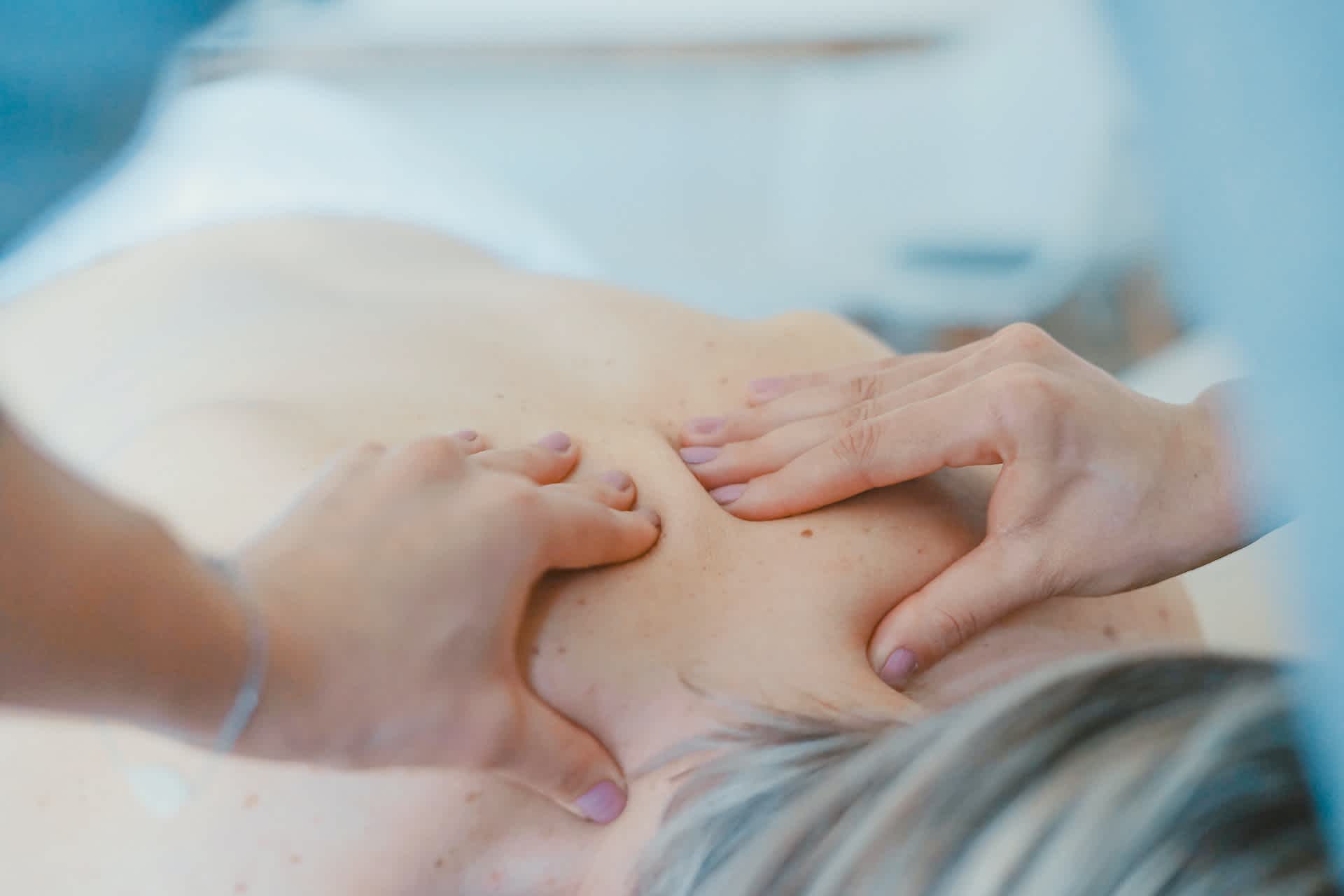 Massage therapist treating a patient's upper back