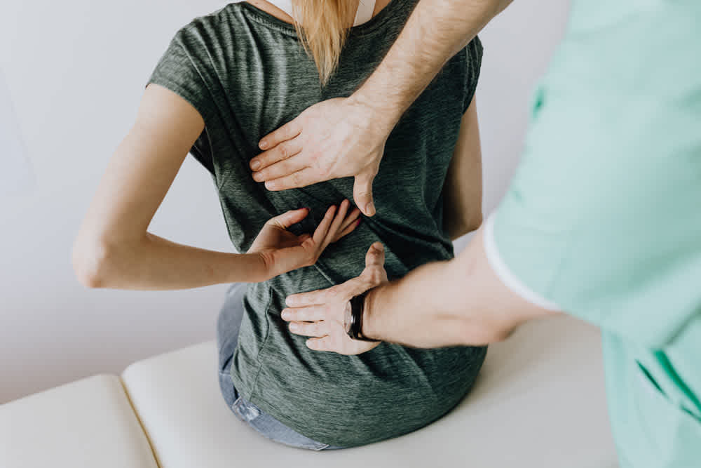 Osteopath touching patient back