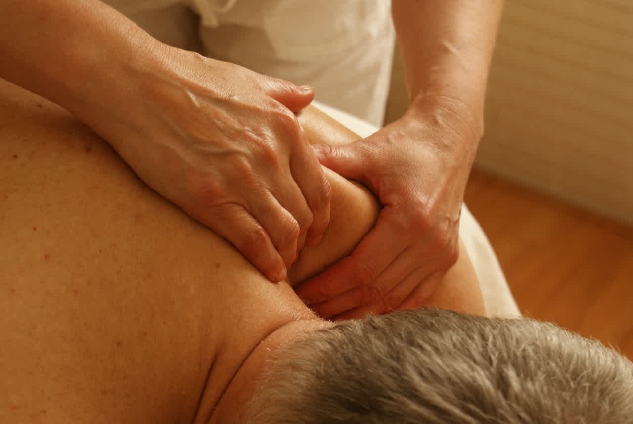 Massage therapist working on man's shoulder
