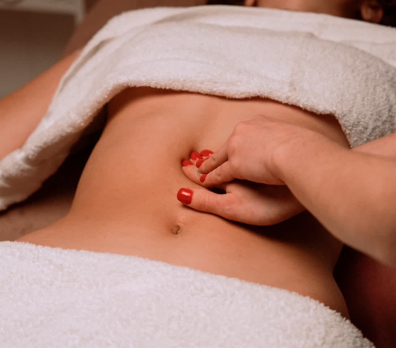 Woman massaging a patient's abdomen
