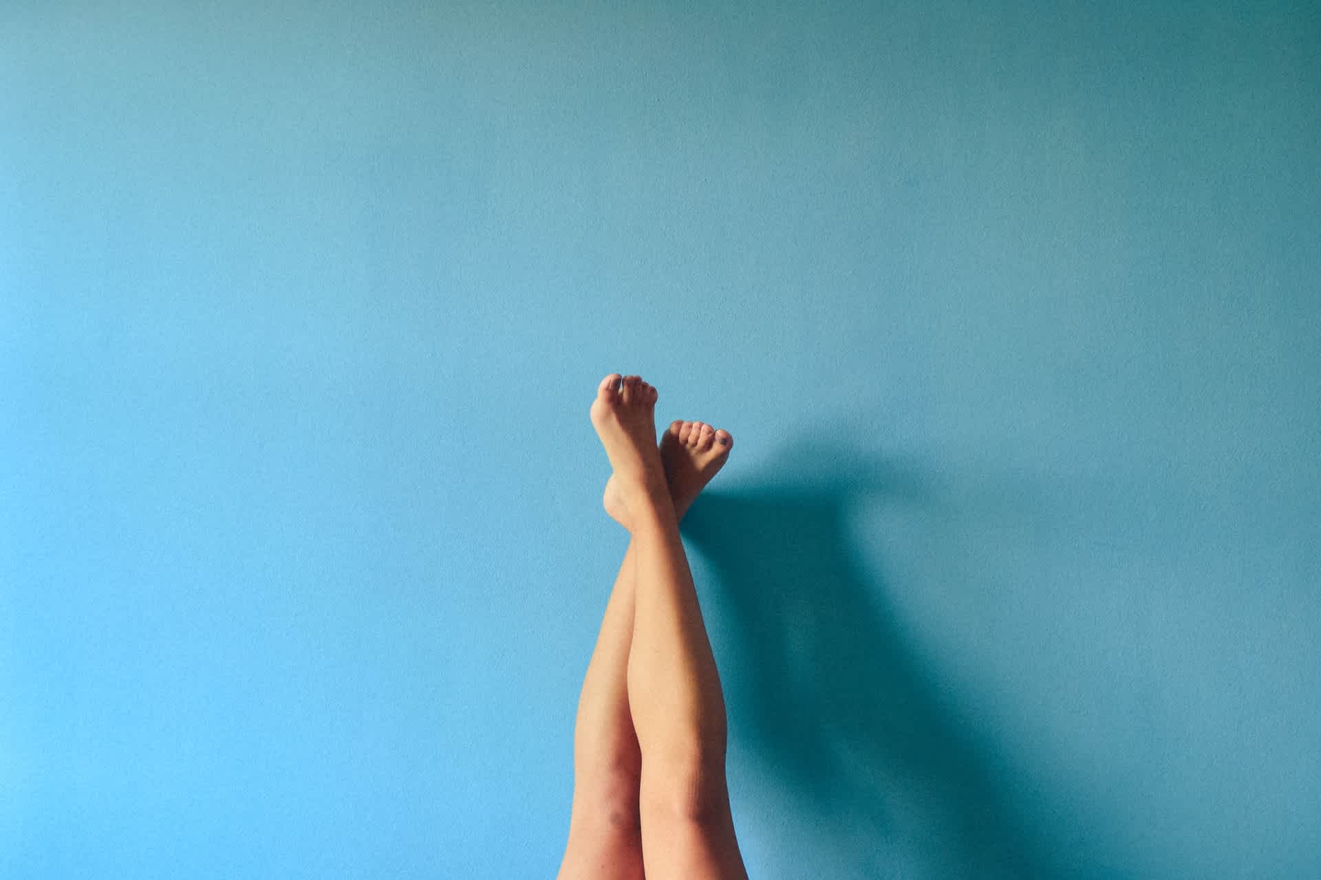 A woman's legs against a blue background