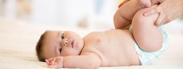 Manos masajeando las piernas del bebe