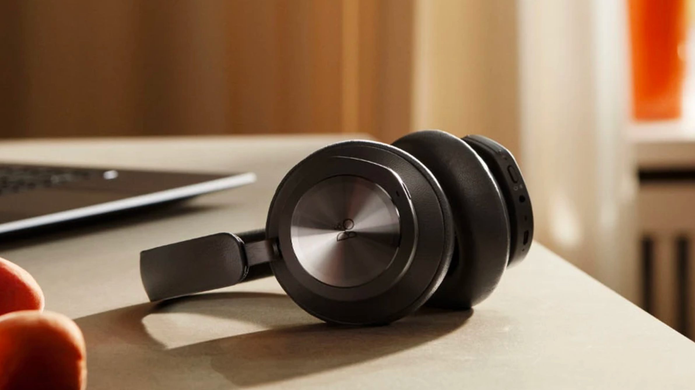 Bang & Olufsen headphones on a desk.