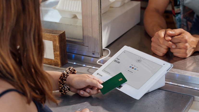 Female making a touchless payment using her bank card on a Clover payment terminal