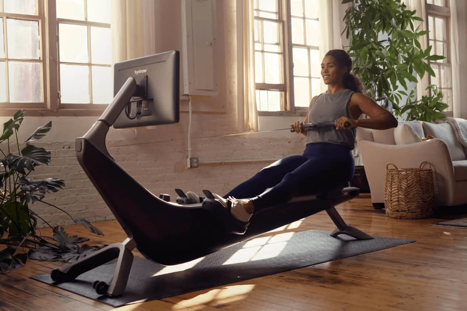 Woman exercising on a Hydrow rowing machine.