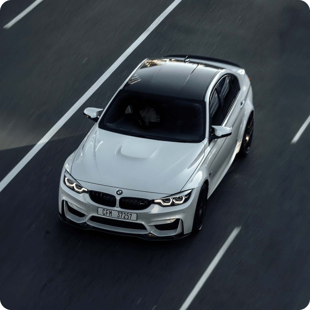 A BMW vehicle drives on a road.