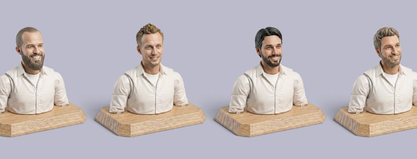 Figurines of the four Userbrain founders on wooden plinths, all wearing white shirts and smiling.