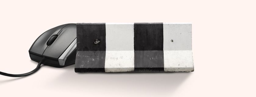 A computer mouse partially obscured by a black and white striped concrete barrier, symbolic of online censorship.