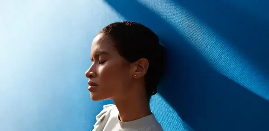 Teenage girl leaning against a wall