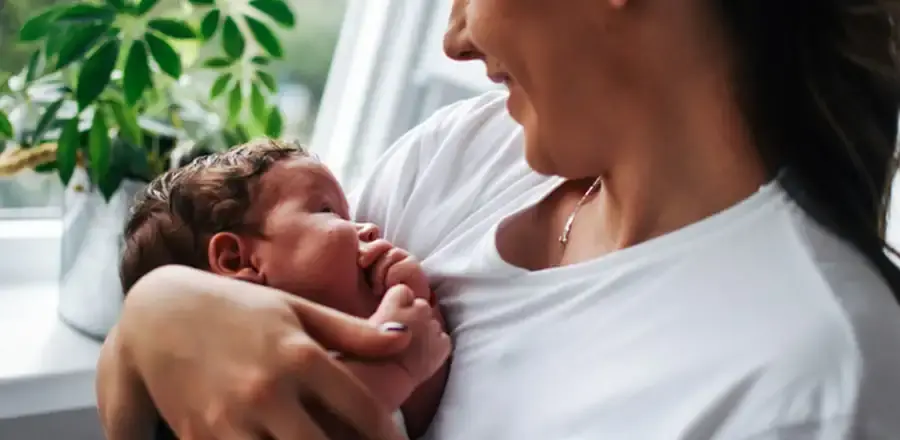 Mother with her newborn baby on her arms