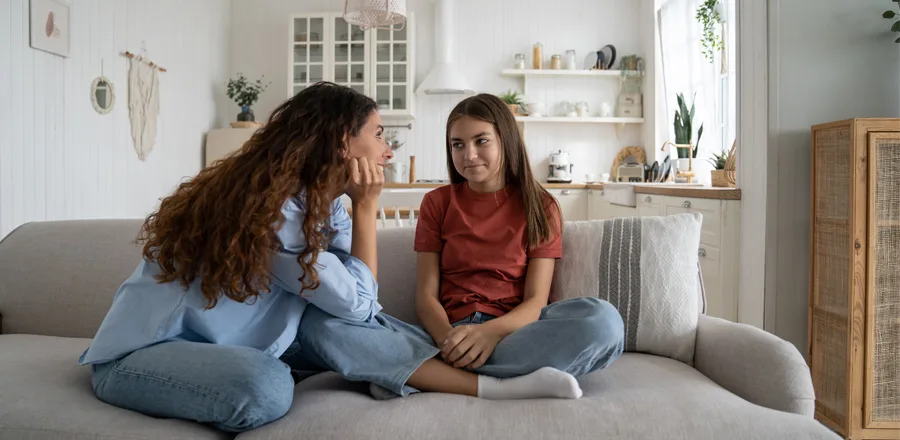 Mom and daughter sitting on the sofa and talking