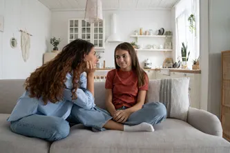 Mom and daughter sitting on the sofa and talking