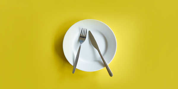A plate with a knife and fork, but no food.