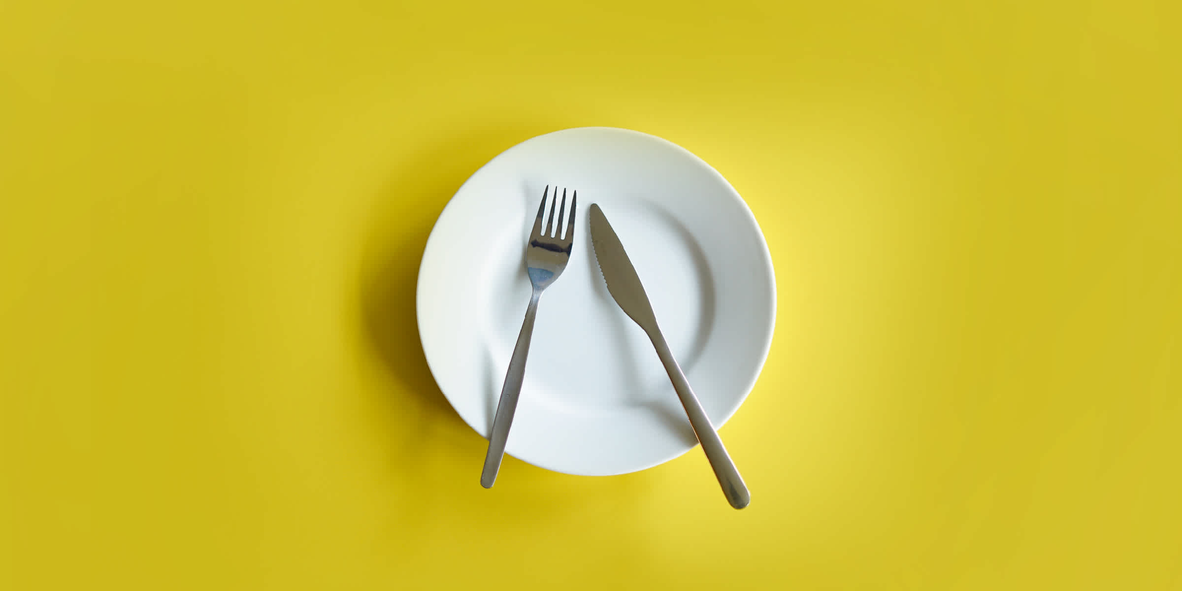 A plate with a knife and fork, but no food.