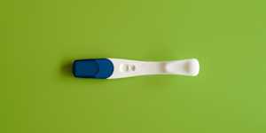 photo of a pregnancy test on a bright green surface