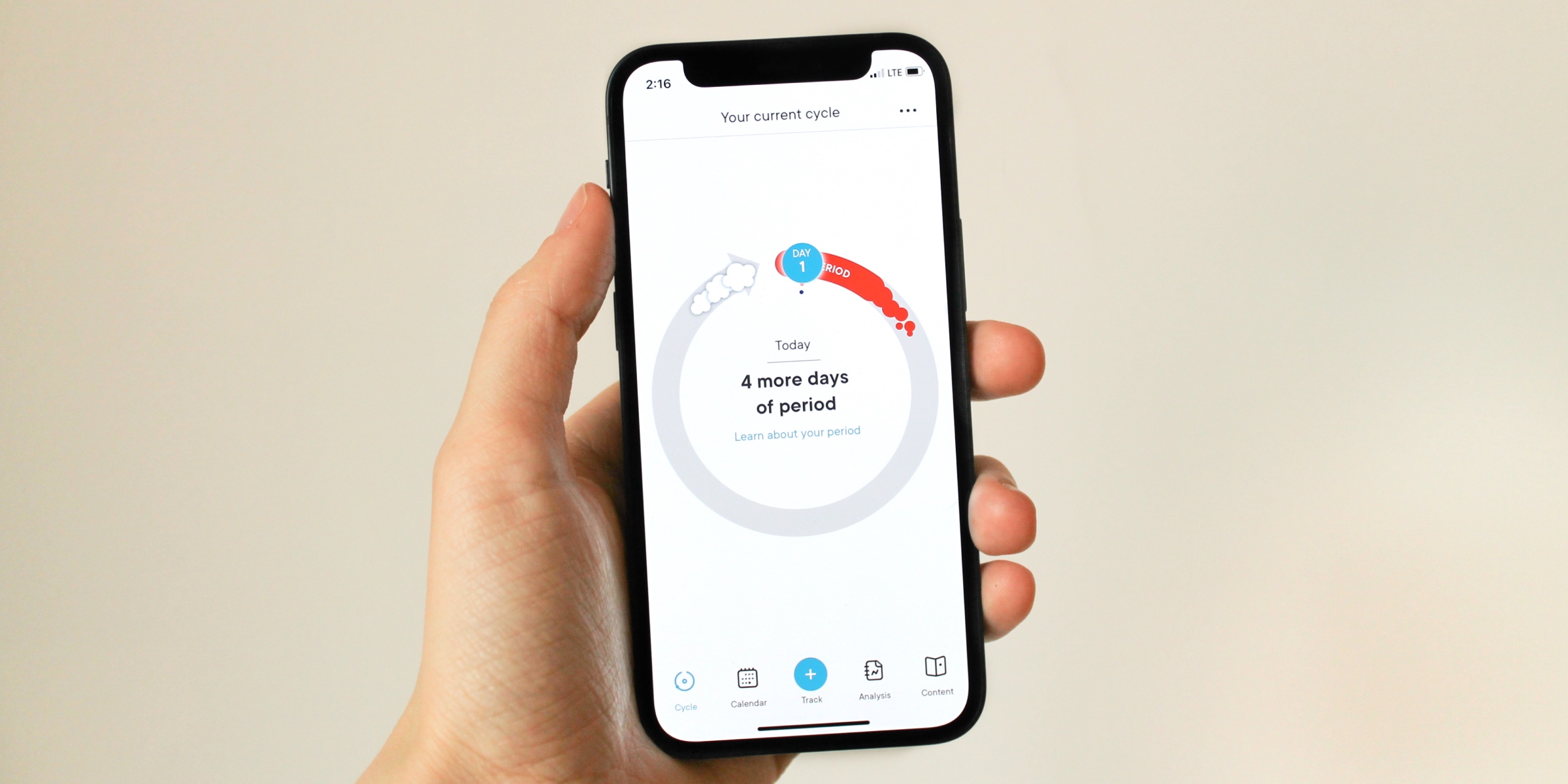 Photo of hands holding phone showing Clue app