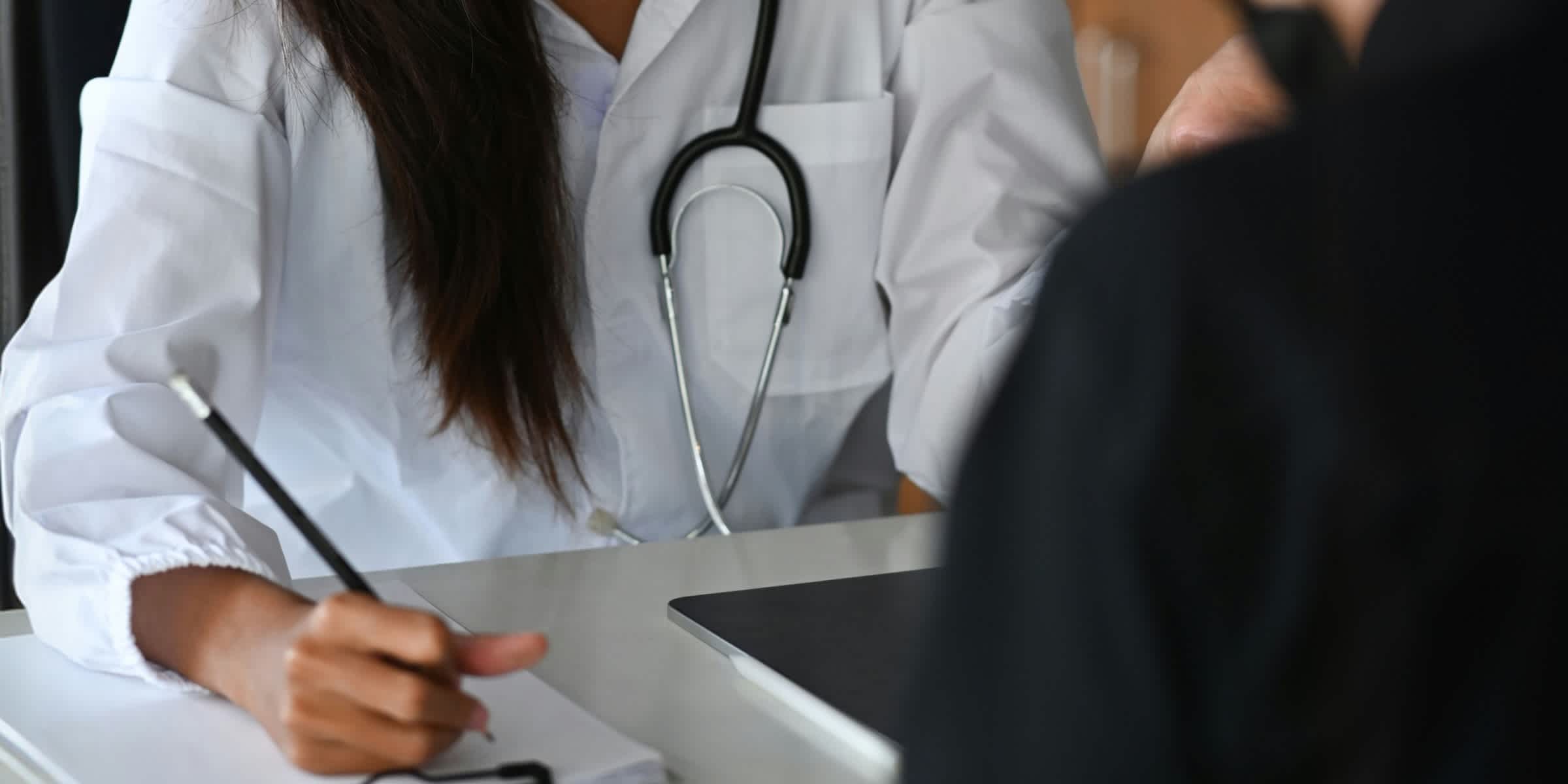 doctor with a notebook and pen seeing a patient