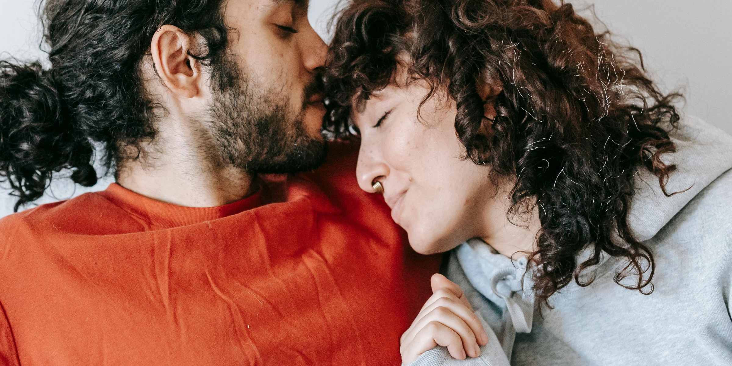 A man in orange jumper and a women leaning into him