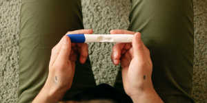 Foto von Elliot, der einen Schwangerschaftstest in der Hand hält