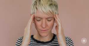 photo of a stressed women holding her head