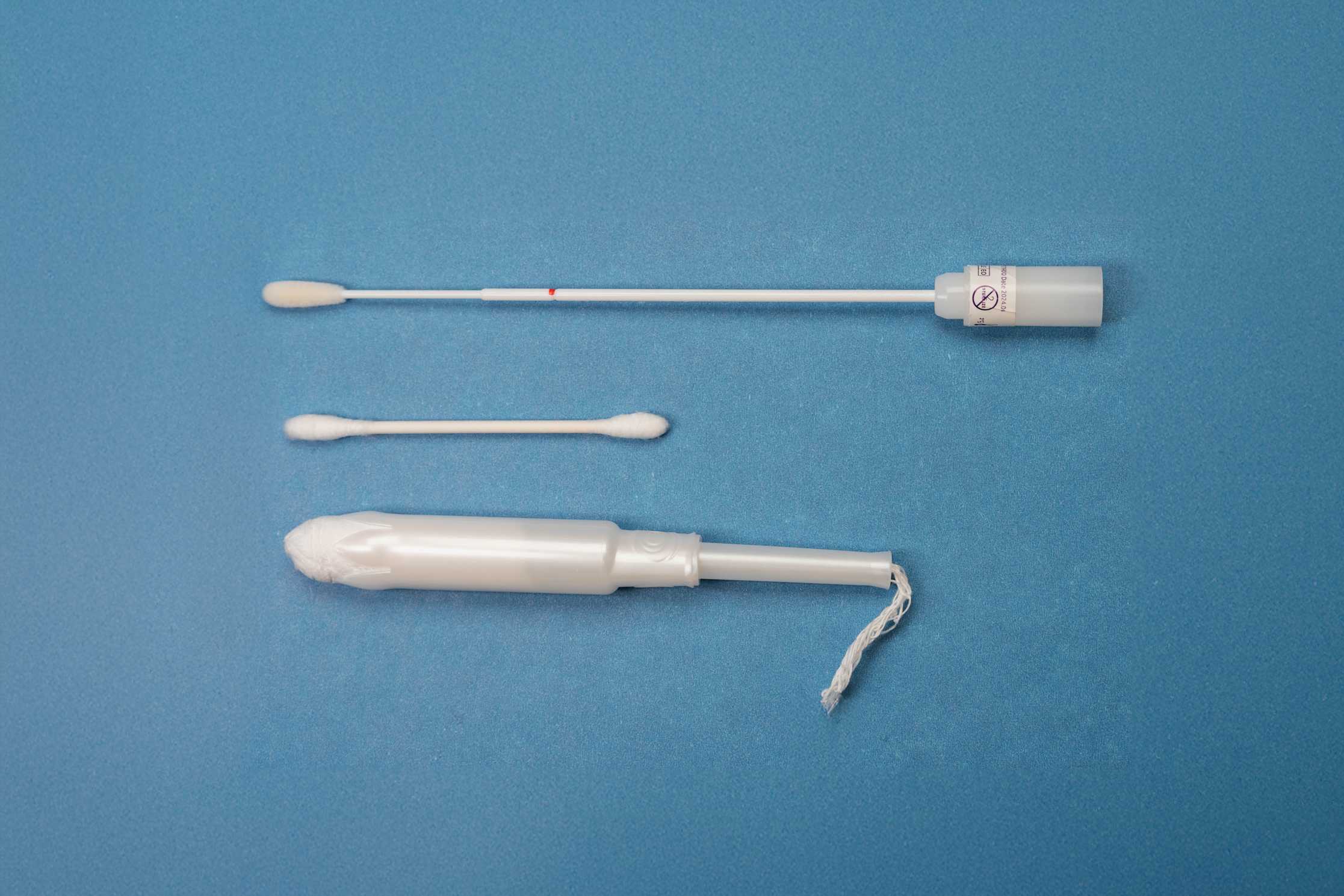A tampon alongside a cotton swab and a HPV self-collection swab